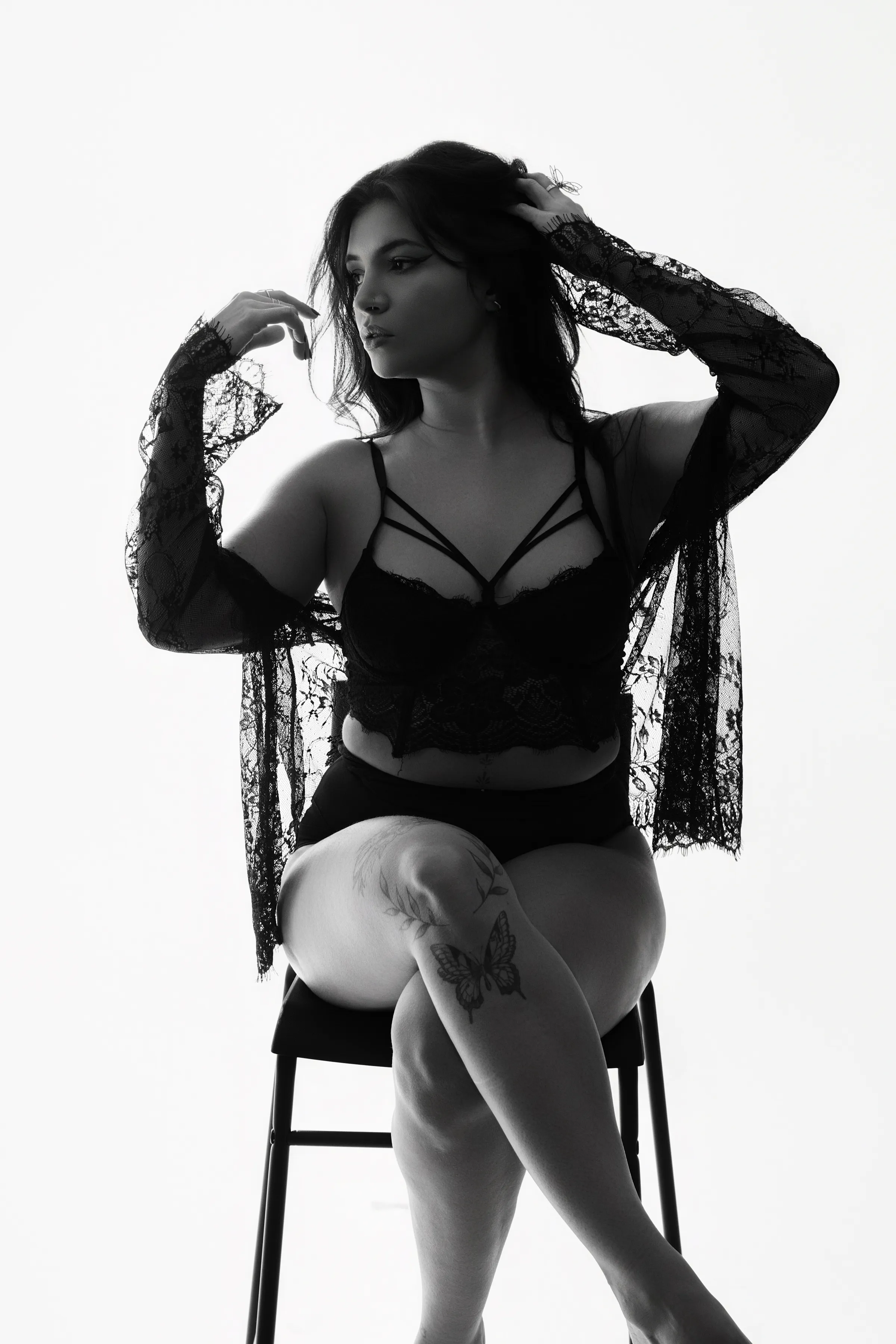 Portrait boudoir en noir et blanc, femme en lingerie de dentelle assise en studio - Cindy Poulet photographe